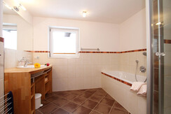 großes Badezimmer mit Badewanne und Regendusche